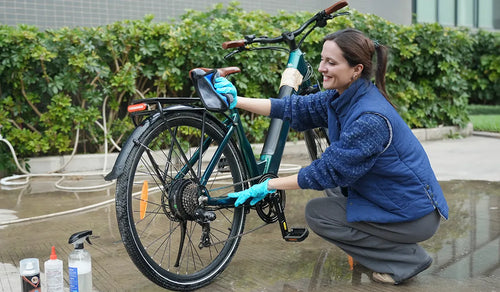 Donna che pulisce il telaio della bicicletta elettrica