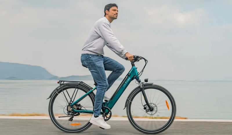 Un uomo guida una bici elettrica Fiido C11 Pro lungo il fiume.