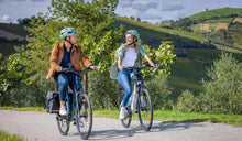 Un uomo e una donna in sella alle bici elettriche Fiido C11 sulla strada