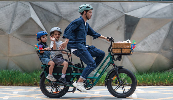 Un uomo guida una bicicletta elettrica Fiido T2 con due bambini