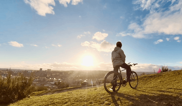 Uomo che guida la bicicletta elettrica Fiido C21 sulla montagna per guardare l'alba