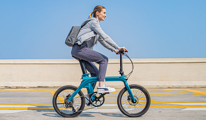 Una donna guida la bici elettrica Fiido X per strada