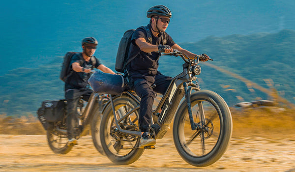 Due uomini in sella a biciclette elettriche