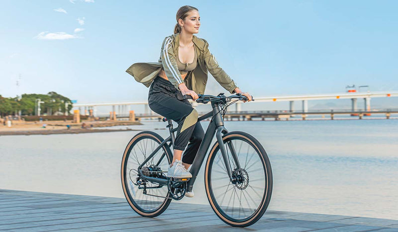 Donna che guida la bici elettrica sul lago