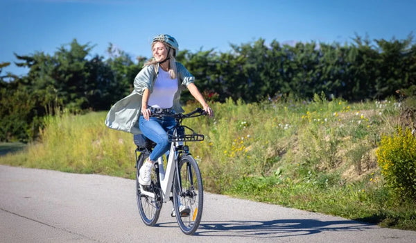 Una donna che guida una bicicletta elettrica Fiido C11 pro in città sulla strada.