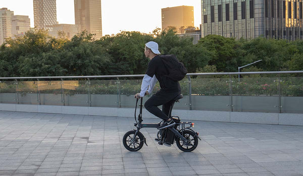 Uomo che guida la bici elettrica Fiido L3 su strada