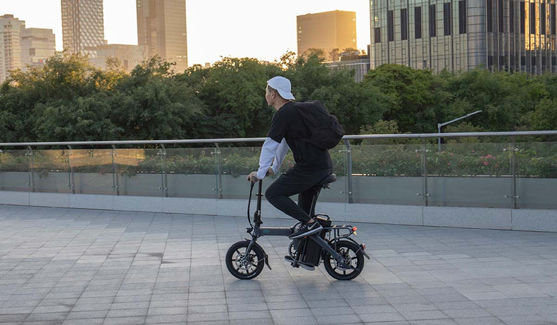 Uomo che guida la bici elettrica Fiido L3 su strada