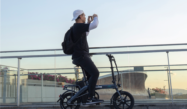 Un uomo guarda il tramonto sulla bici elettrica Fiido L3