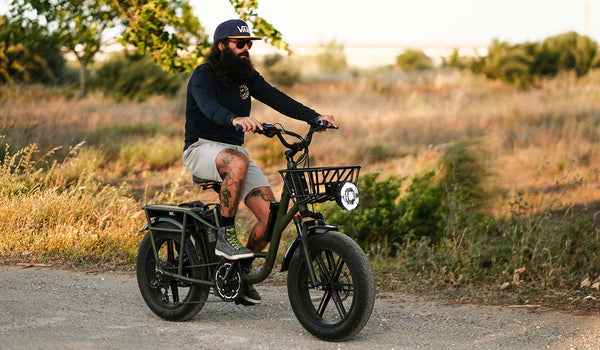 Bici elettrica Fiido T1pro accanto a una tenda nella foresta.