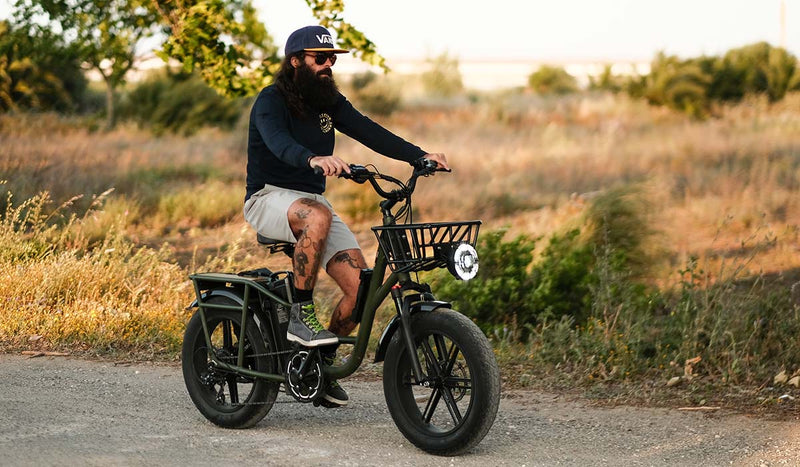 Bici elettrica Fiido T1pro accanto a una tenda nella foresta.