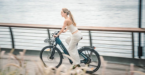 Una donna sta guidando una bicicletta elettrica urbana leggera Fiido C11 Pro sulla strada.
