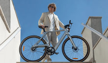 Un uomo sta guidando una bici elettrica Fiido Air in carbonio in città.