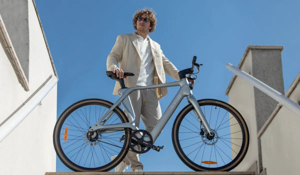 Un uomo sta guidando una bici elettrica Fiido Air in carbonio in città.