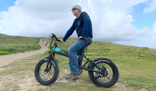 Ciclista su Fiido M1 Pro fat bike elettrica su un sentiero sterrato in collina