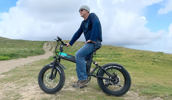 Ciclista su Fiido M1 Pro fat bike elettrica su un sentiero sterrato in collina