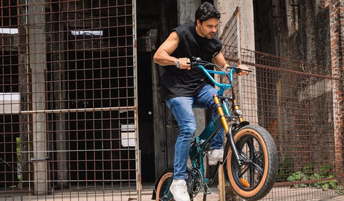 Un uomo sta guidando una bici elettrica da montagna Fiido M1 Pro su un sentiero di montagna.