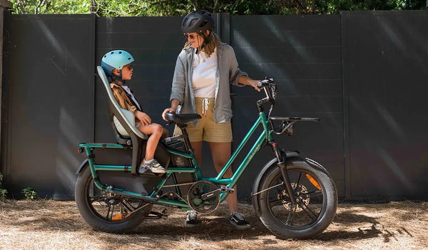 Una donna utilizza una bicicletta elettrica Fiido T2 con seggiolino posteriore per bambini.