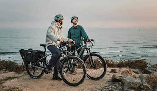 Coppia in sella a una e-bike Fiido Nomads Pro su un sentiero di montagna fuoristrada