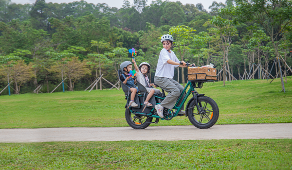 Una madre trasporta i suoi figli su una e-bike Fiido T2 Longtail Cargo per una gita primaverile.