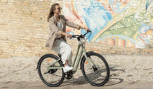 Una donna guida per strada una bicicletta elettrica Fiido C700.