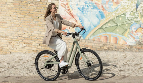 Una donna guida per strada una bicicletta elettrica Fiido C700.